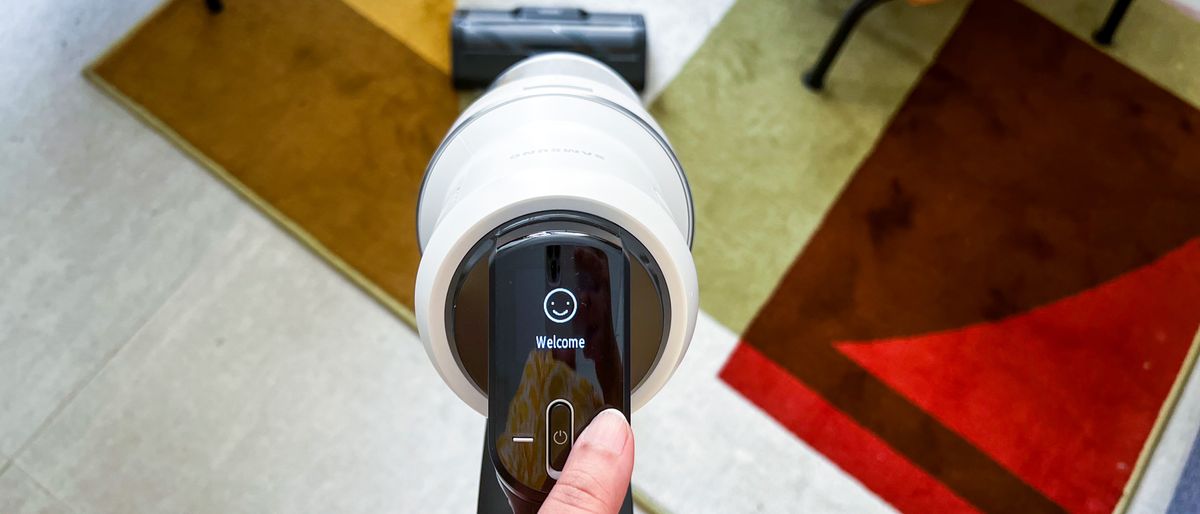 Hand holding the Samsung Bespoke Jet AI cordless vacuum as it begins its initial setup