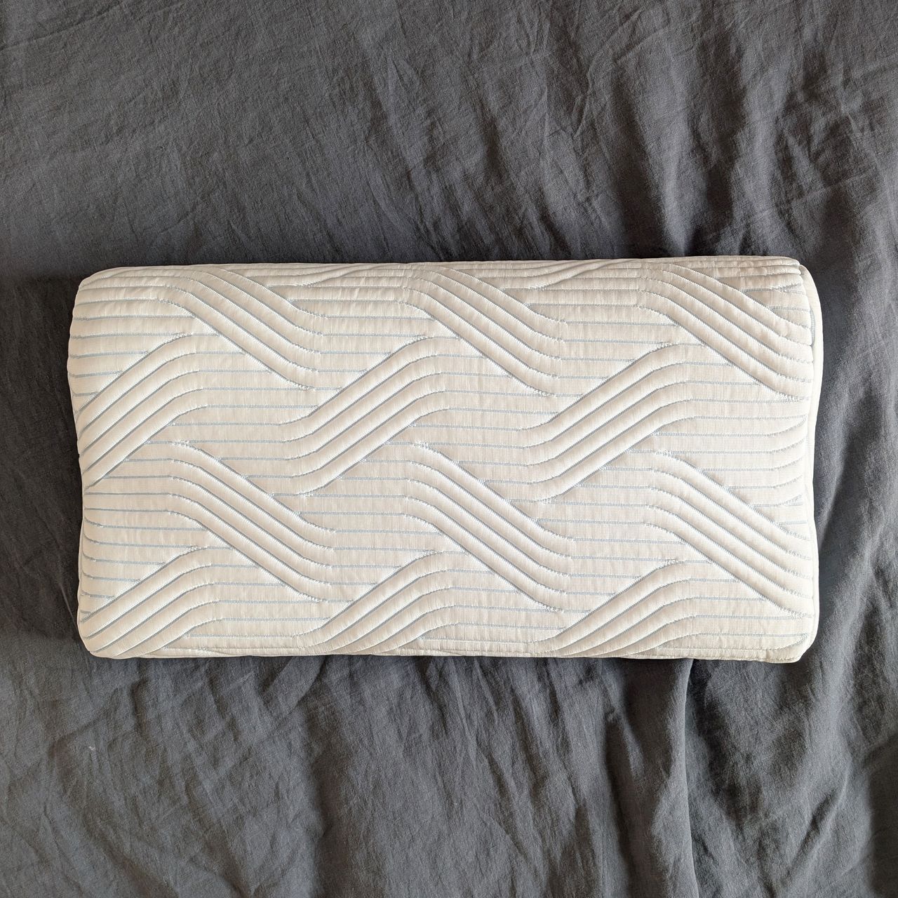 The Tempur Original SmartCool Pillow, flat side facing up on grey bedding
