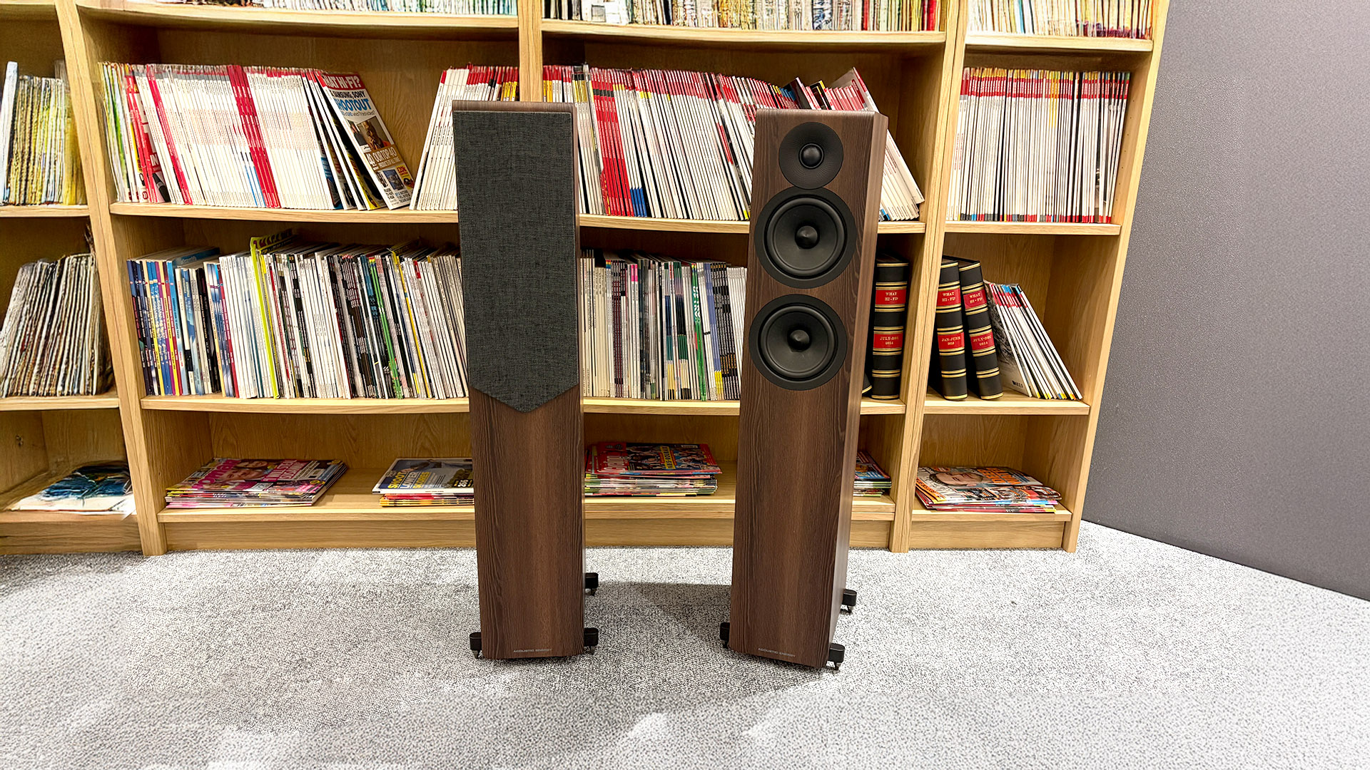 Acoustic Energy AE309 Mk2 floorstanding speakers in front of bookcase, one has baffle attached