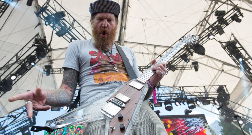Brent Hinds plays his lucite Electrical Guitar Company V onstage with Mastodon and pulls a face for the camera
