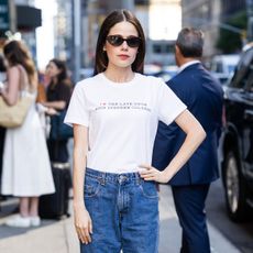 Molly Gordon wearing a white Stephen Colbert T-shirt, jeans, and black pointed-toe pumps in NYC