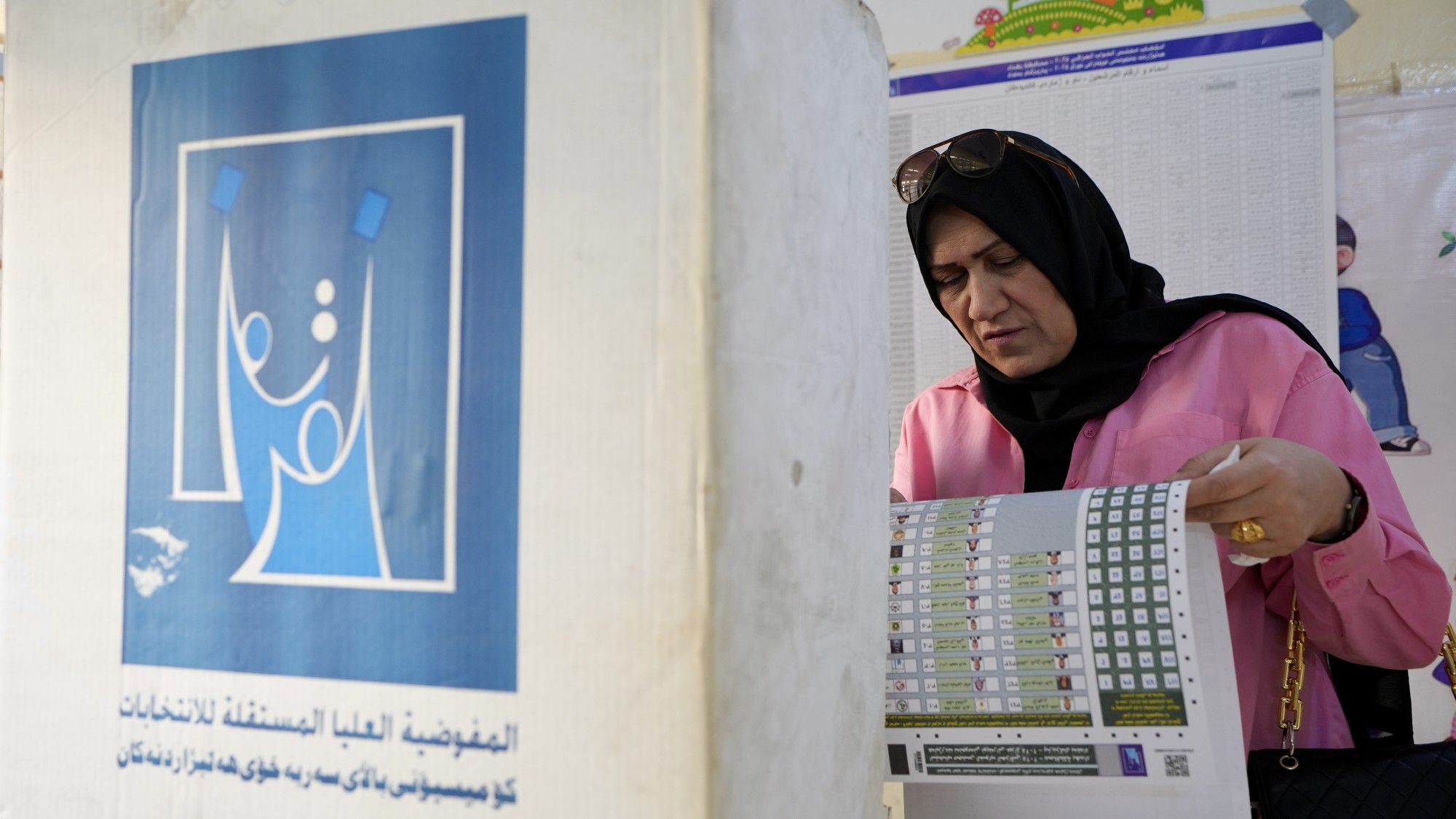 An Iraqi woman casts her vote at the Iraqis Al-Amal School as the country holds parliamentary elections
