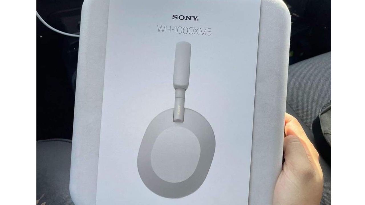 Sony WH-1000XM5 wireless headphones retail box held in an adult male&#039;s hand