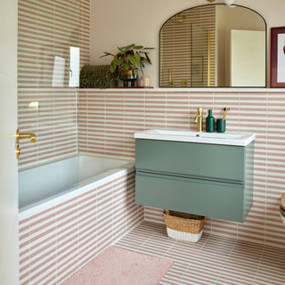 A bathroom that has been tile drenched with white and pink tiling.