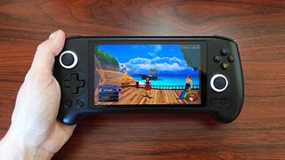 Hand holding Anbernic RG556 handheld with Kingdom Hearts gameplay on screen.