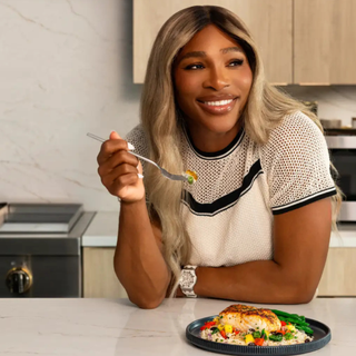 Woman enjoying a salmon meal on her kitchen counter