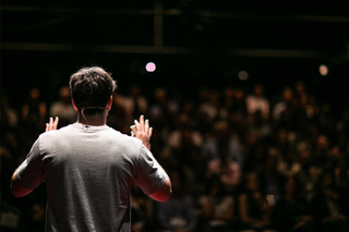 Rear view of man giving a talk to an audience