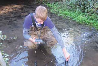 Green Lake High School student measures pH and dissolved oxygen on a tributary of Green  