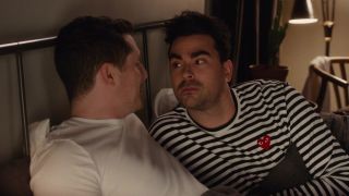 Noah Reid and Dan Levy having a talk in bed in Schitt's Creek.