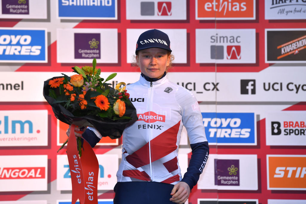 RUCPHEN NETHERLANDS DECEMBER 18 Puck Pieterse of The Netherlands and Team Alpecin Fenix on White UCI CycloCross Worldcup JuniorLeader Jersey poses the podium ceremony after the 9th Rucphen UCI CycloCross Worldcup 2021 Womens Elite CXWorldCup UCIcyclocrossWC on December 18 2021 in Rucphen Netherlands Photo by Luc ClaessenGetty Images
