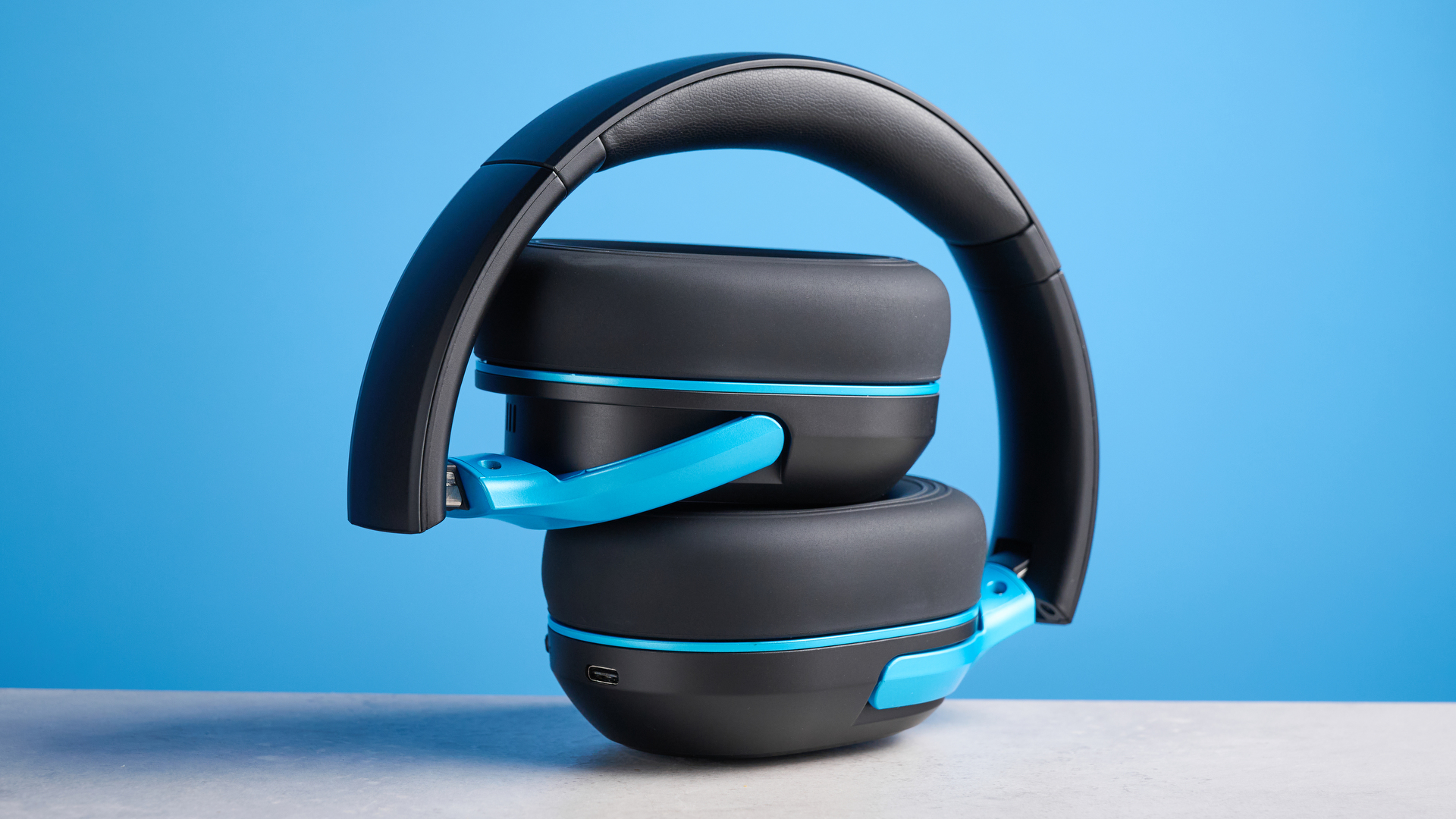 H2O RIPT Ultra headphones in black with blue accents photographed on a blue background