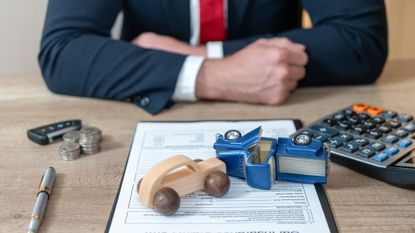 two model cars collide on a legal document on the desk of a lawyer
