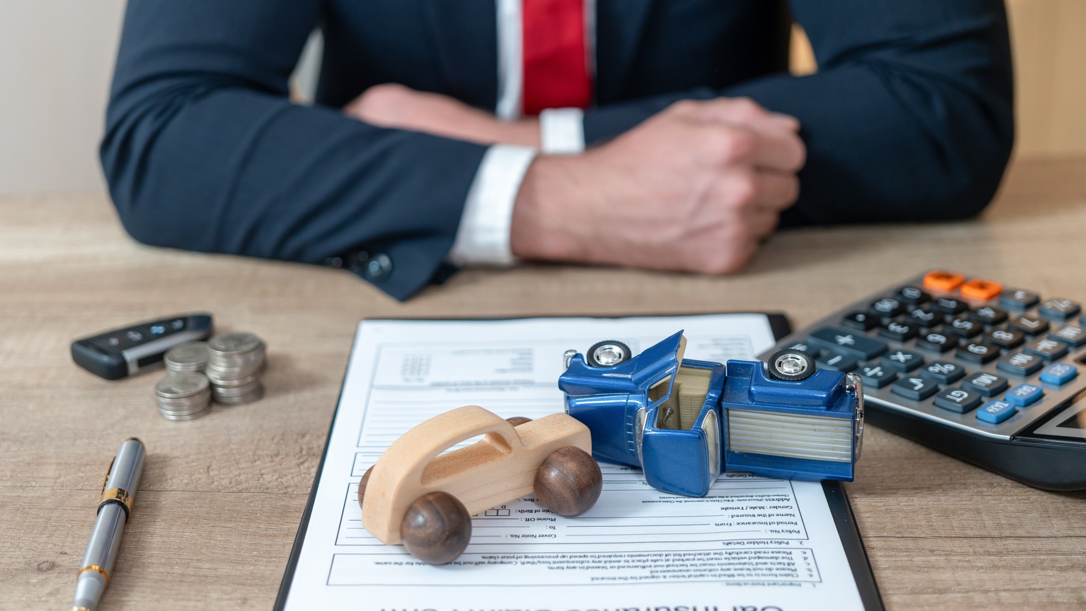 two model cars collide on a legal document on the desk of a lawyer