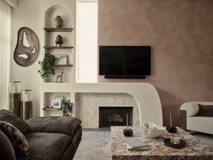 A living room with pink walls, a stone fireplace, and a marble coffee table