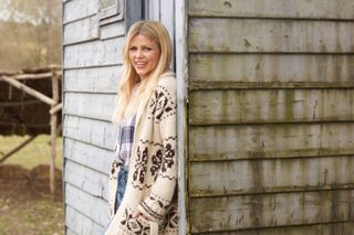 Ellie Harrison from Countryfile leaning against a shed