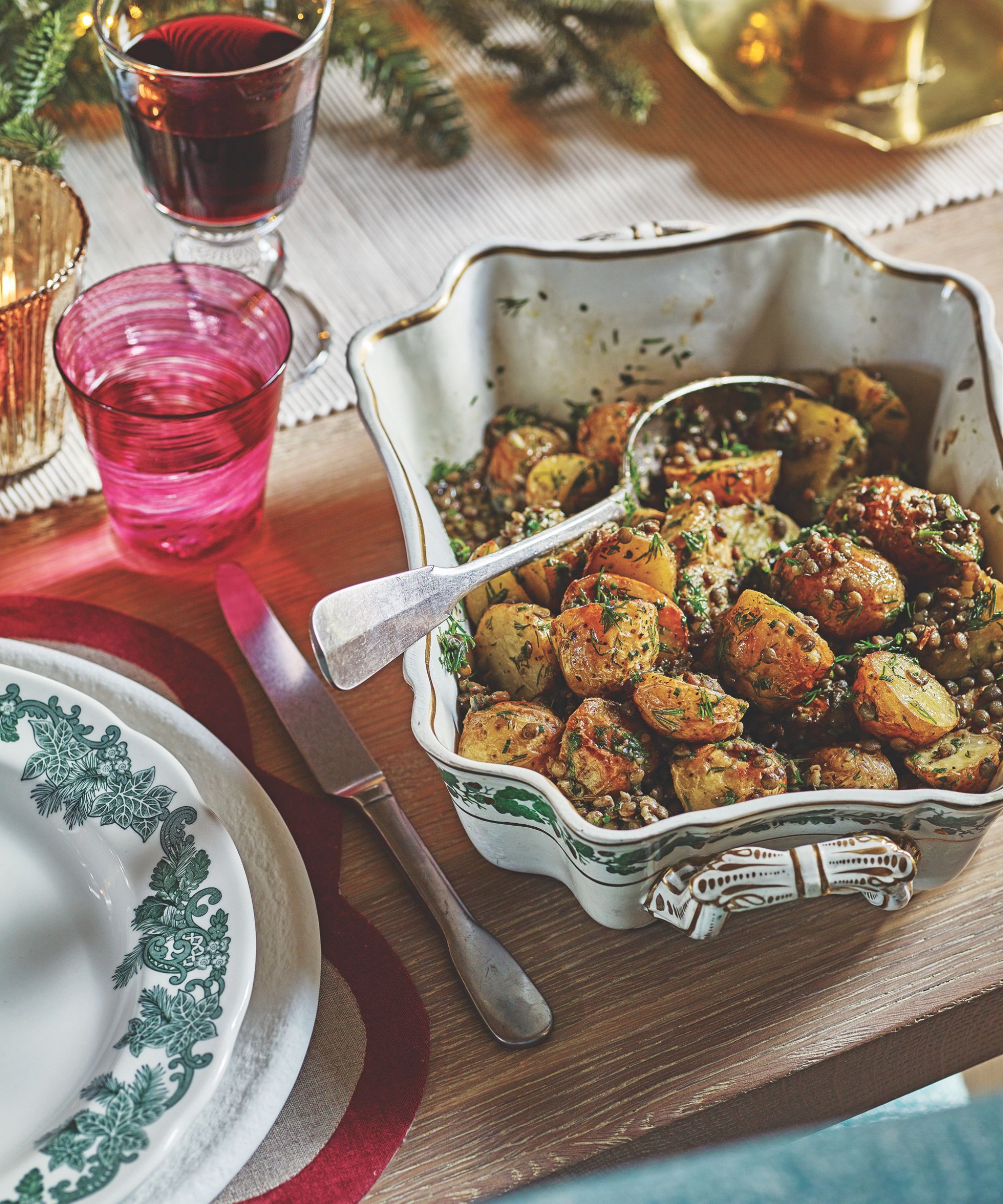 Christmas table with dish of potatoes and colored glasses