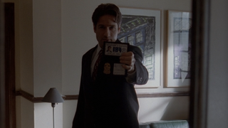 Mulder pointing a gun in the "Small Potatoes" episode of The X-Files