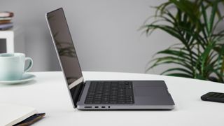 MacBook Pro 14" fra siden, stående på et bord.