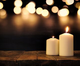 Candles on a wooden table with candles in the background