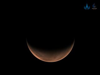 China's Tianwen-1 spacecraft orbiting Mars captured this stunning view of a crescent Red Planet on March 18, 2021. Shown here is the planet's northern hemisphere from a distance of 6,850 miles (11,000 kilometers).