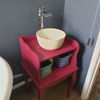 mat red side chair with round wash basin and faucet with plain weave basket