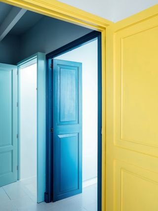 An open blue door and yellow wall