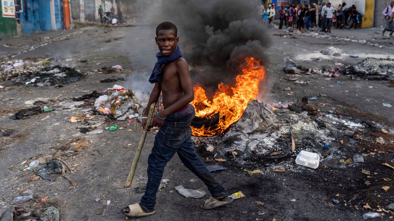 A man walks past a burning barricade during a protest against Haitian prime minister Ariel Henry in Port-au-Prince in October