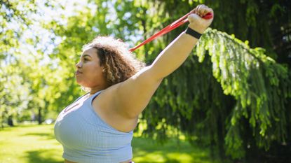 Woman working out with resistance band in park
