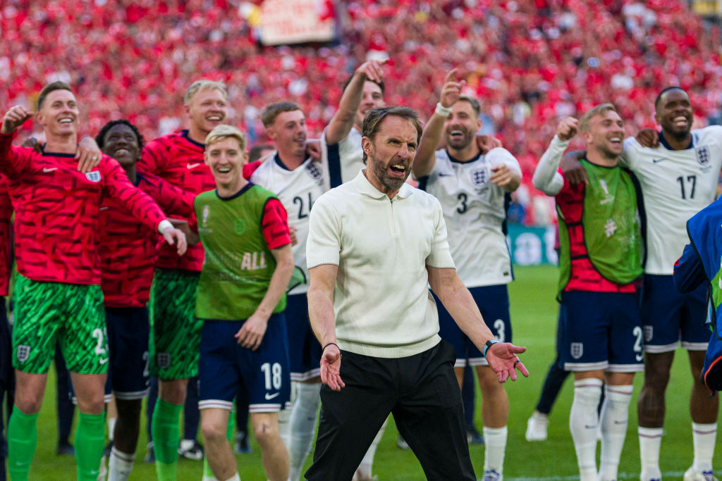 England players including Cole Palmer, Declan Rice and Luke Shaw celebrate together behind Gareth Southgate at Euro 2024