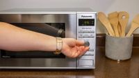microwave deals | a hand using the dial on the Panasonic NN-SD372SR microwave