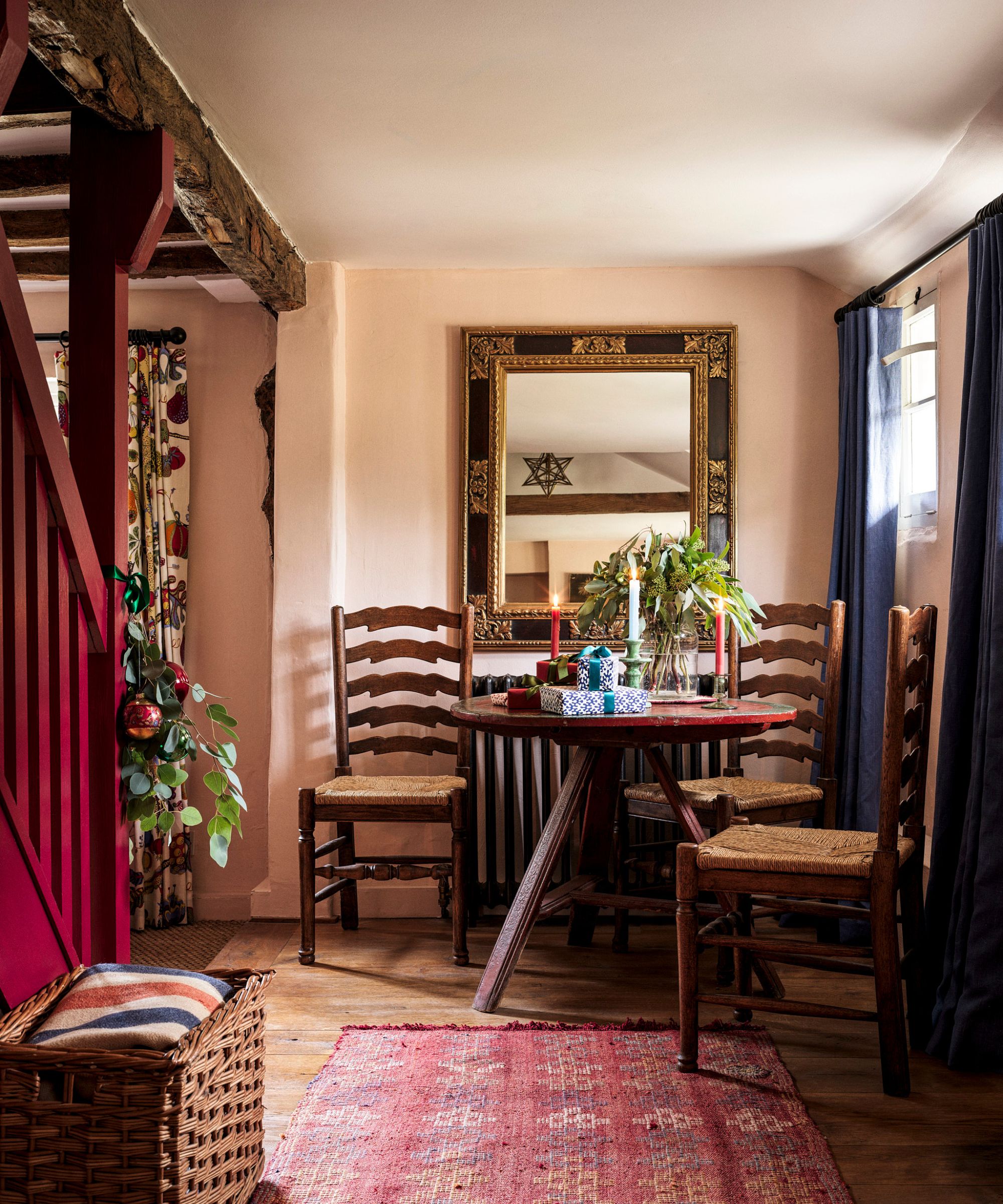 Entryway decorated for Christmas with a seating area in one corner made up of a circular wooden table and wooden chairs
