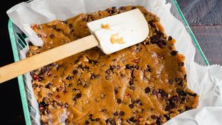 A spatula being used to smooth a tray bake mixture