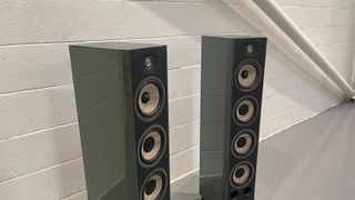 Focal Aria Evo X No3 floorstanding speakers slight angle against white brick wall