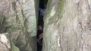 Woman's feet trapped between boulders