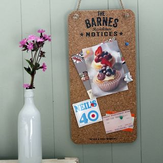 Delightful Living Personalised Cork Noticeboard hanging against green wall next to white vase with pink flowers