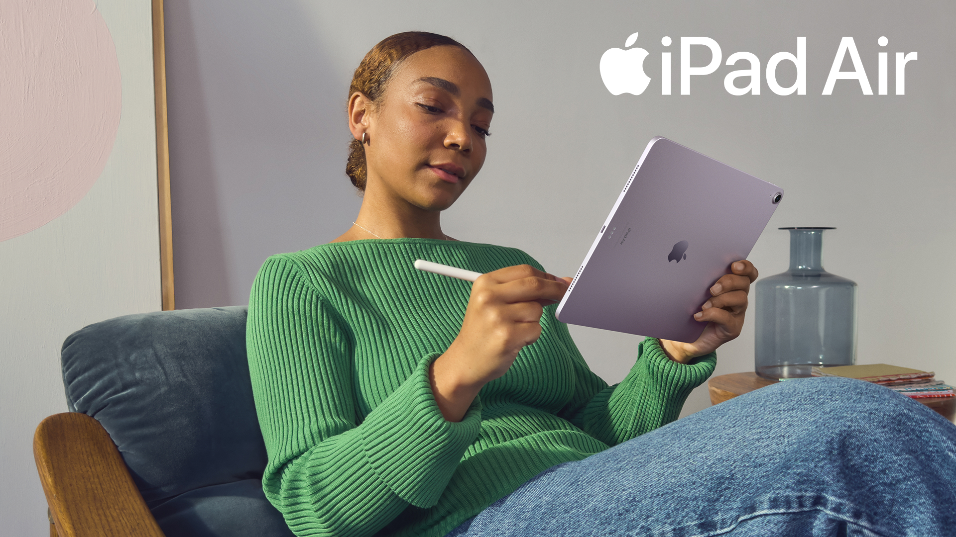 Promotional image of the iPad Air being used by a young woman in a green top