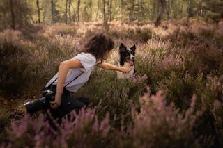 dog in field with woman bts shot.