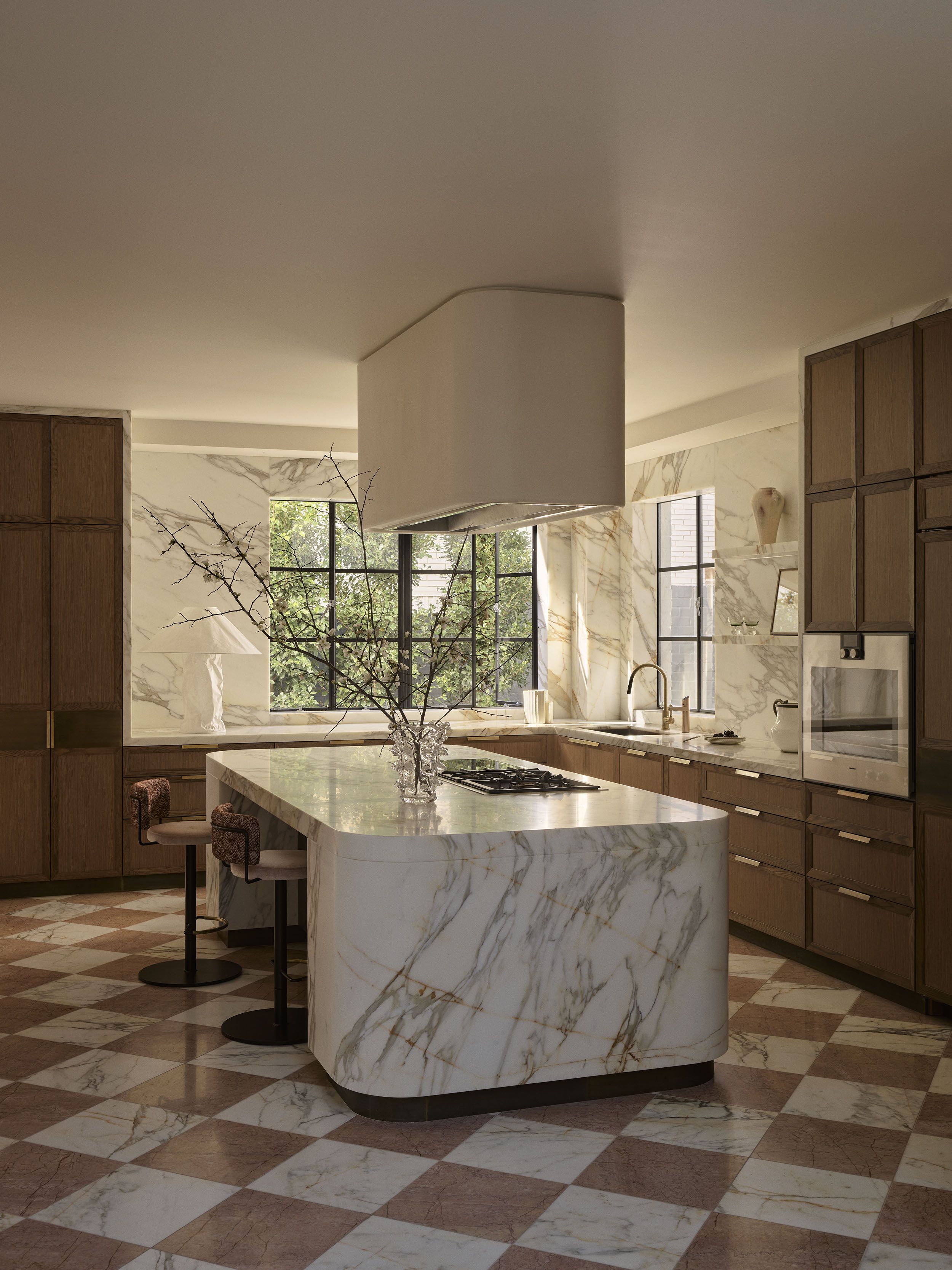 Rosa Murcia marble kitchen island with Calacatta Oro marble walls, warm timber cabinetry and a pink checkerboard floor in Smac Studio's renovated Art Deco home in Woollahra, Sydney.
