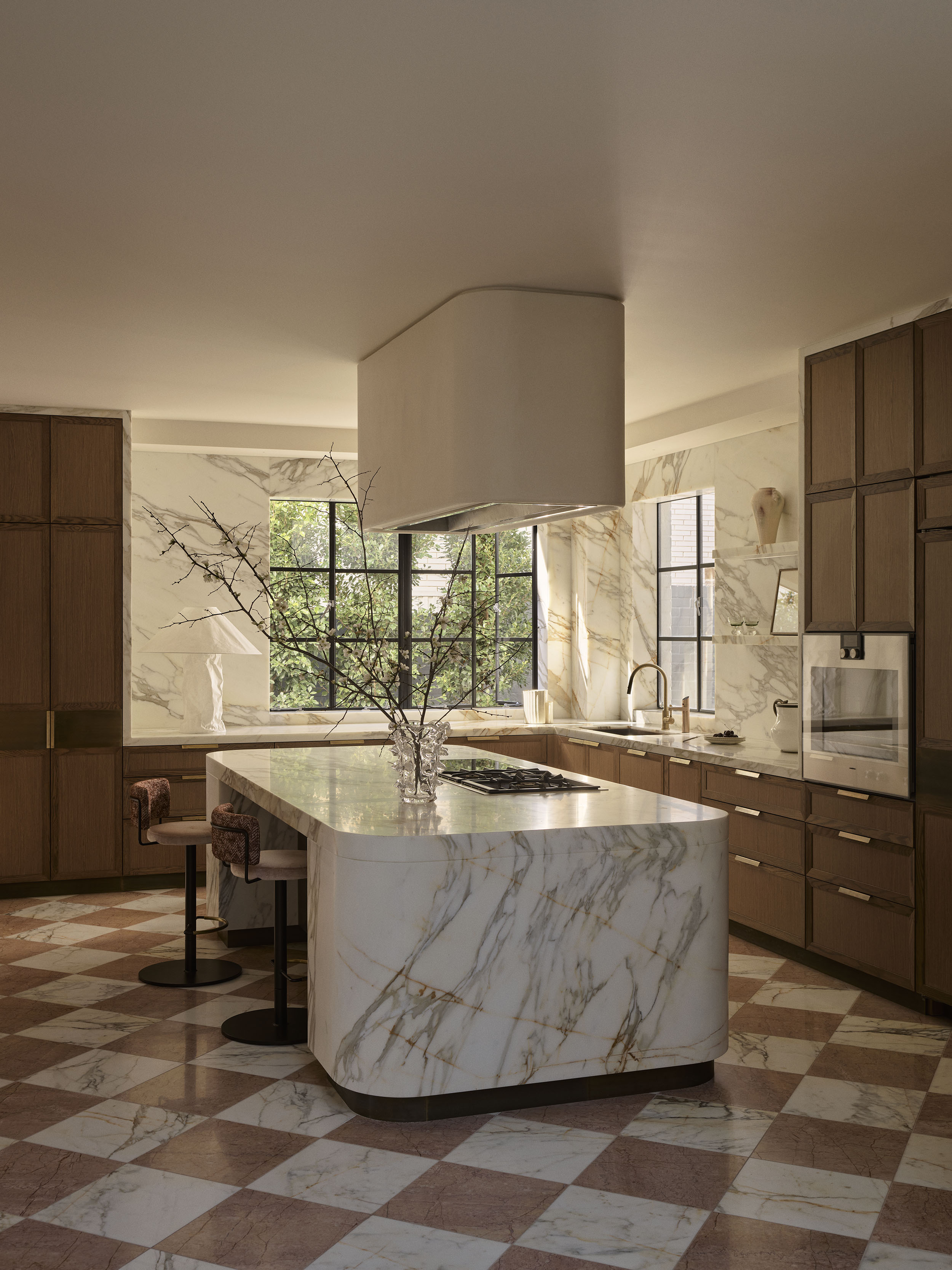 Rosa Murcia marble kitchen island with Calacatta Oro marble walls, warm timber cabinetry and a pink checkerboard floor in Smac Studio's renovated Art Deco home in Woollahra, Sydney.