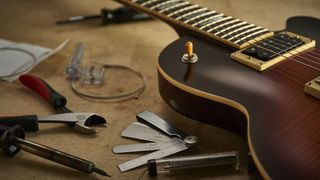 Guitar on a work bench surrounded by tools
