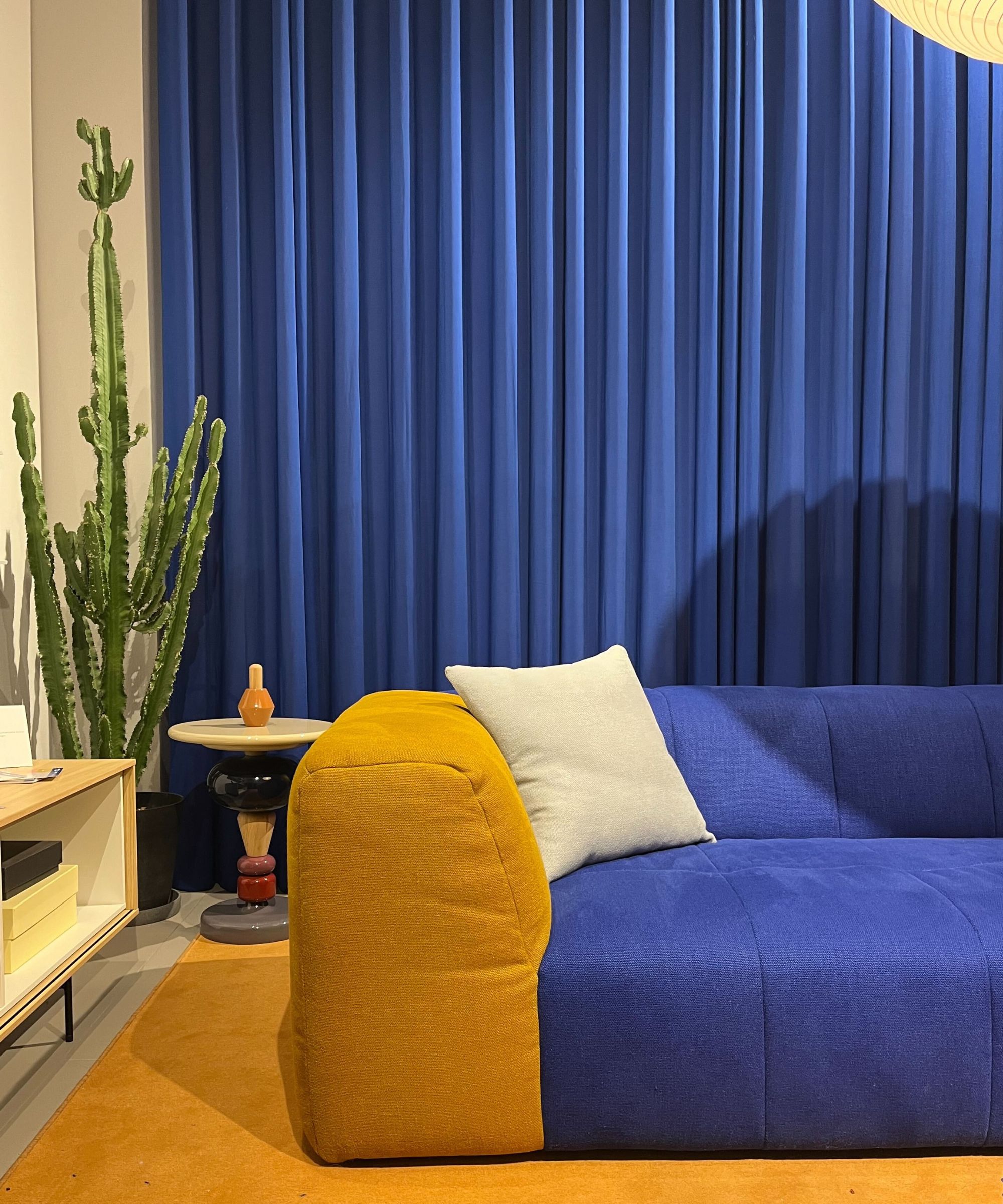 Blue and yellow sofa, blue curtains in background