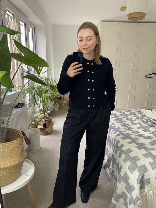 Florrie wears a textured cardigan and pinstripe trousers by H&M