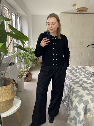Florrie wears a textured cardigan and pinstripe trousers by H&M