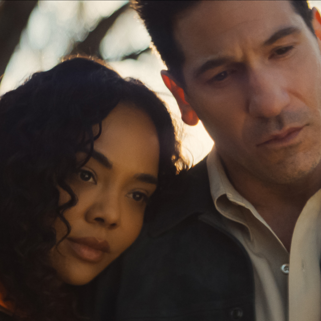 tessa thompson as anna leaning her head on jon bernthal as jack's shoulder in a somber still from his and hers
