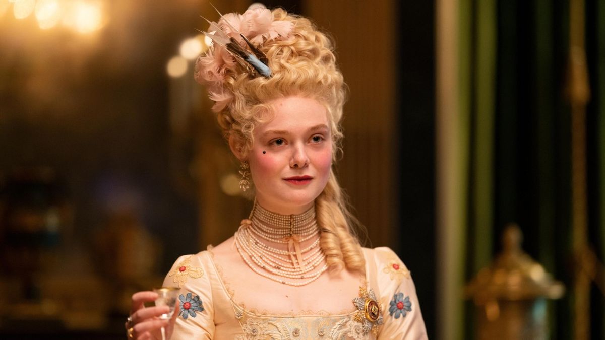 Elle Fanning as Catherine holding up a small glass in The Great.