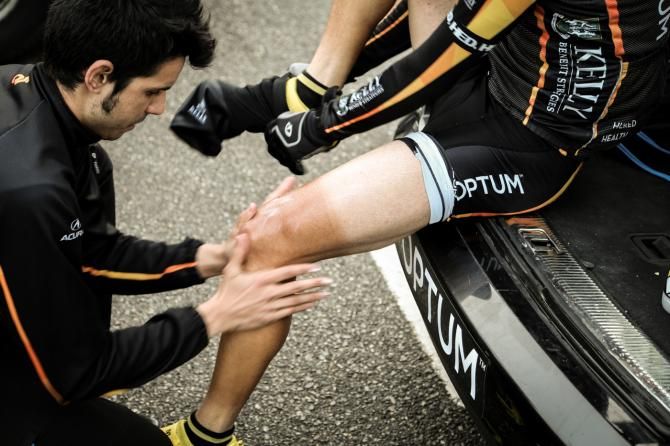 Guest soigneur Pablo de Pedro warms up the athlete's legs with some embrocation before the race
