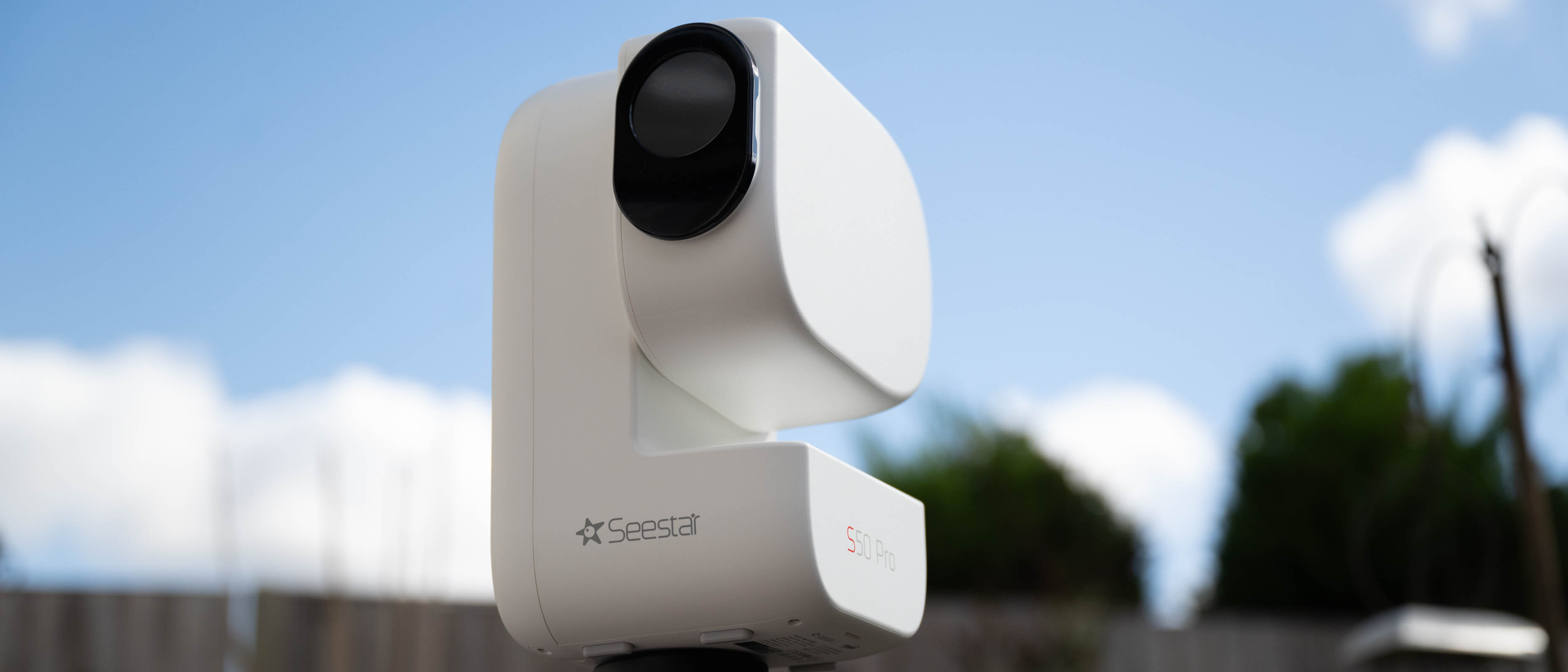 ZWO Seestar S50 pro smart telescope on a tripod in front of a daytime sky