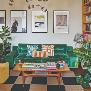 A living room with an emerald green velvet sofa, a chequered rug and a mustard yellow chair