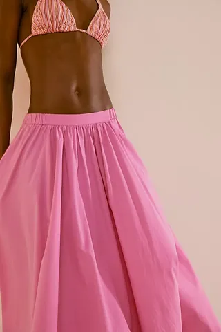 seorang model mengenakan rok A-line merah muda bertingkat rendah