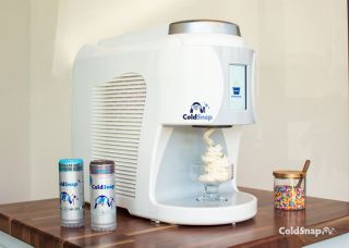 ColdSnap machine sitting on wooden table with two pods